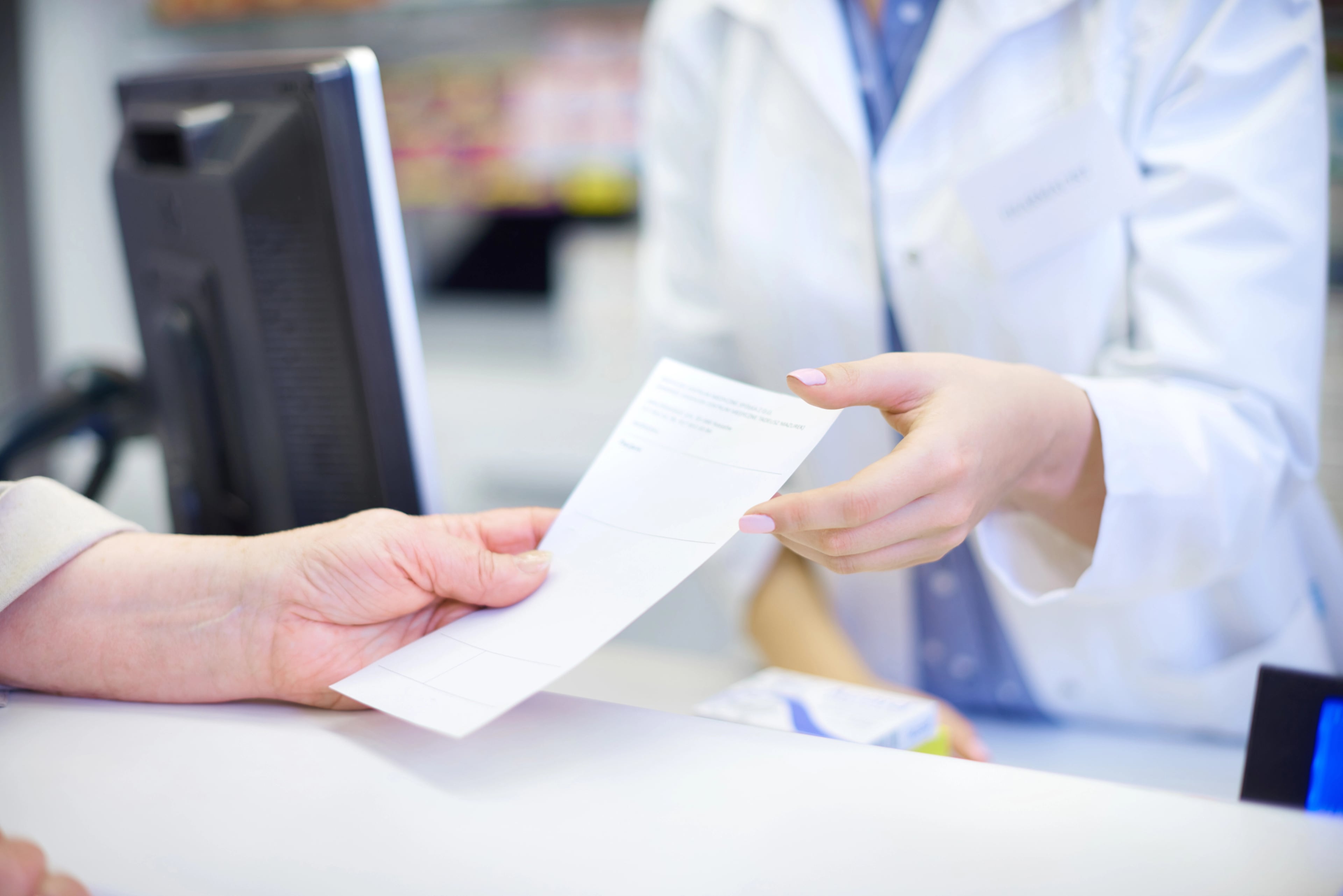 Pharmacist helping a patient with prescription pricing